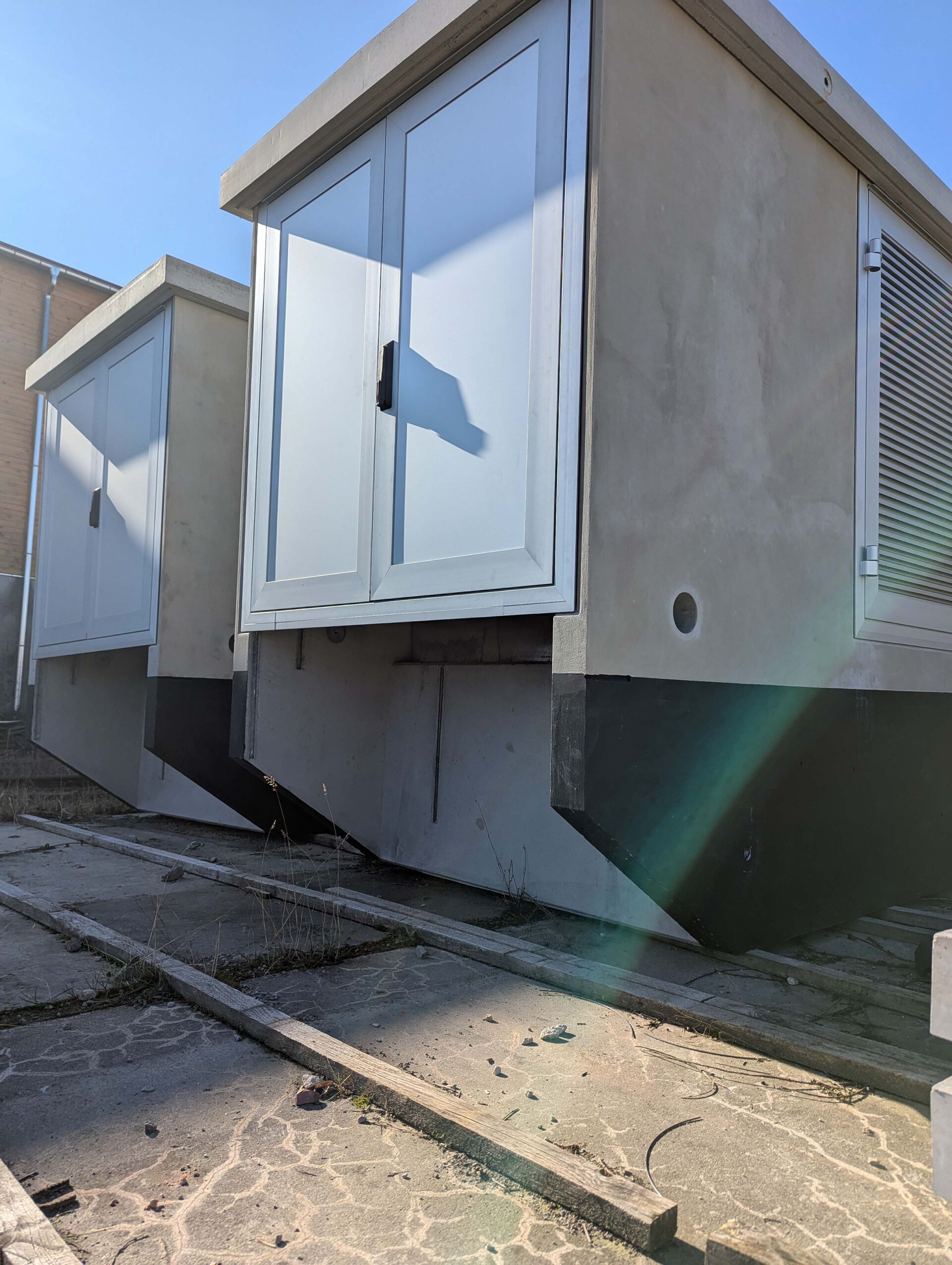 Zwei Trafo-Kompaktstationen aus Beton mit Aluminiumtüren & Lüftungsgitter an der Seite